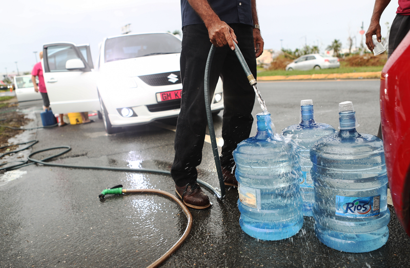 People in Dorado fill water jugs as shortages continue. Image credit: Mario Tama/Getty